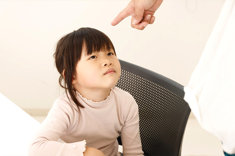 親から理不尽な叱責を受ける少女