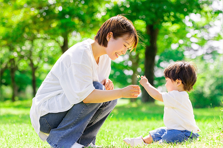 新緑の中で息子とコミュのケーションを取る母親