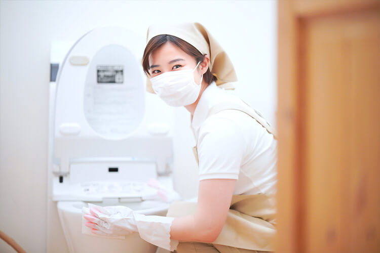 笑顔でトイレ掃除する女性